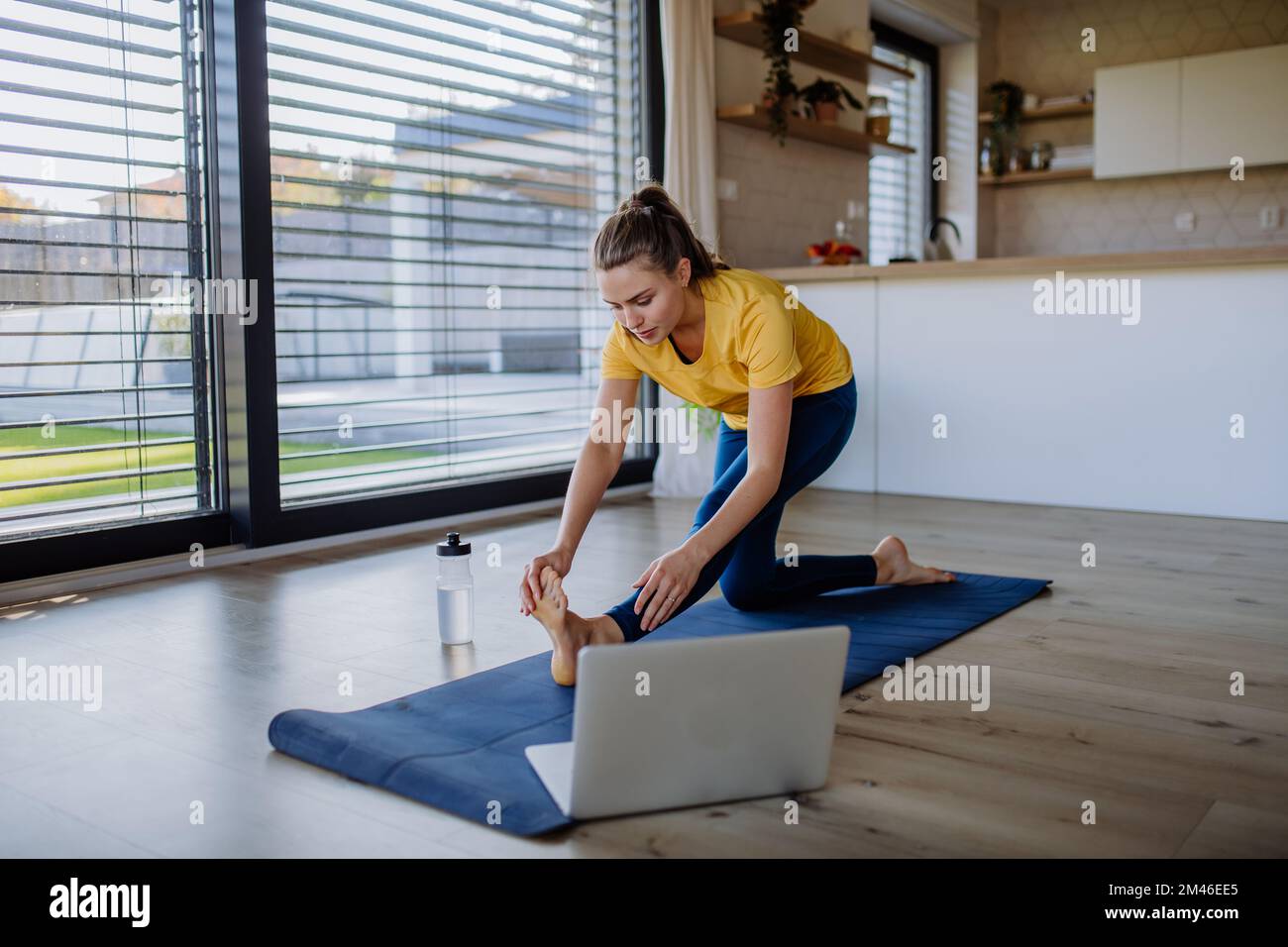 Young woman doing an exercises at home. Stock Photo