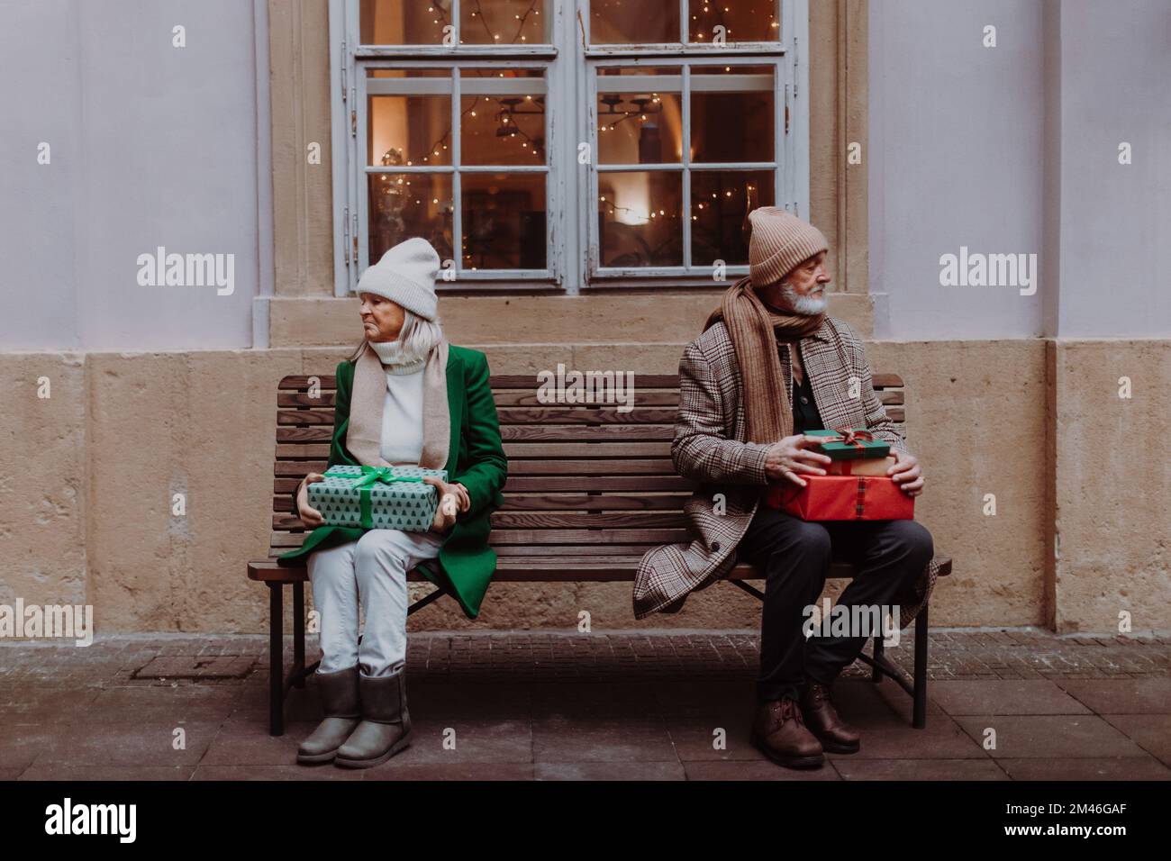 Offended senior couple citting on city bench. Stock Photo