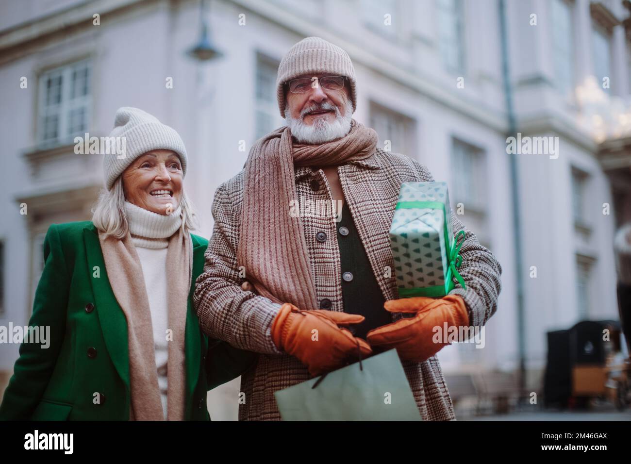 Happy senior couple enjoying christmas market, buying gifts. Stock Photo