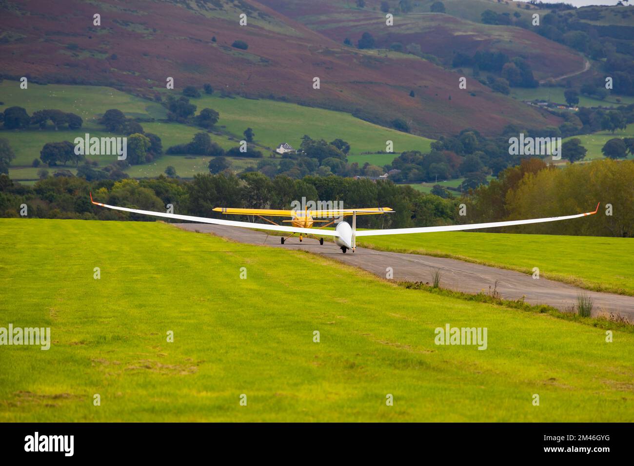 RAFGSA Duo Discus glider sailplane on aerotow launch behind Eurofox tug plane. llewni Parc airfield, Dendigh, Wales Stock Photo