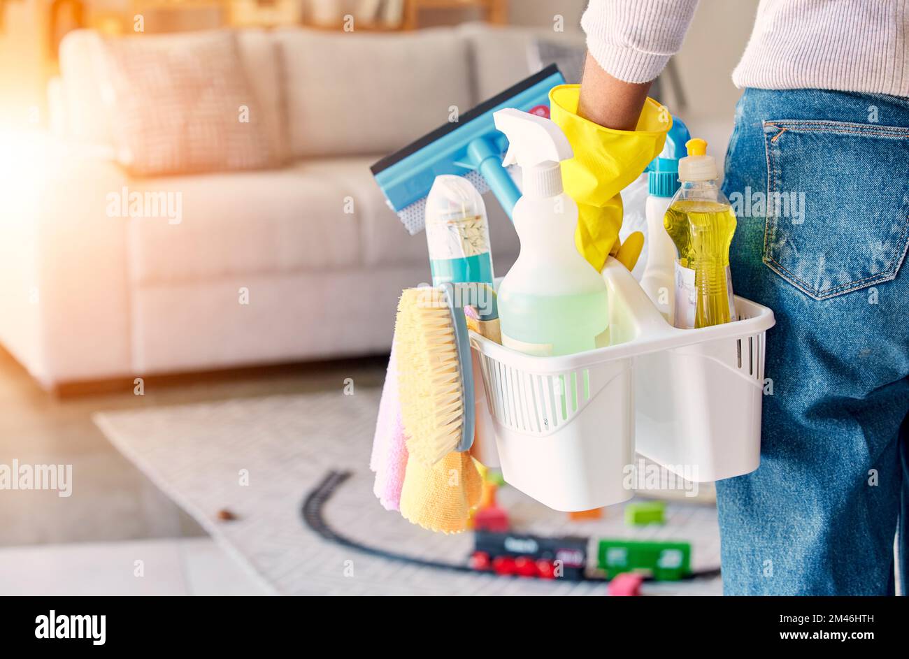 Cleaning, hand and basket of cleaning supplies for family home hygiene with a brush, bottles and gloves. Woman, cleaning supplies and housekeeper Stock Photo