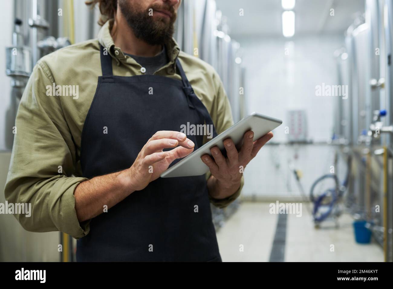 Small business owner checking craft beer brewing equipment in brewery Stock Photo