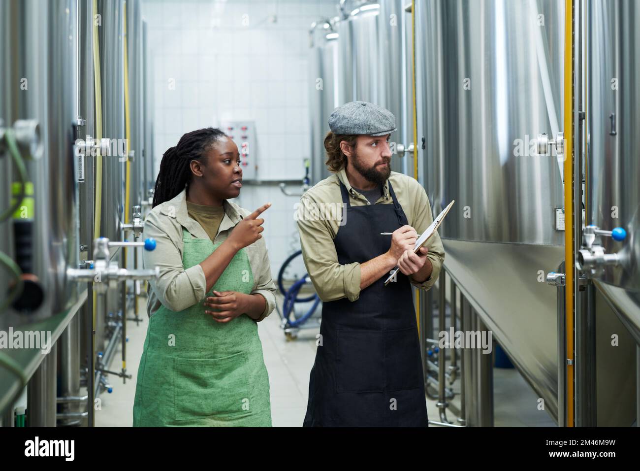 Beer brewery manager explaining work to new employee who is taking