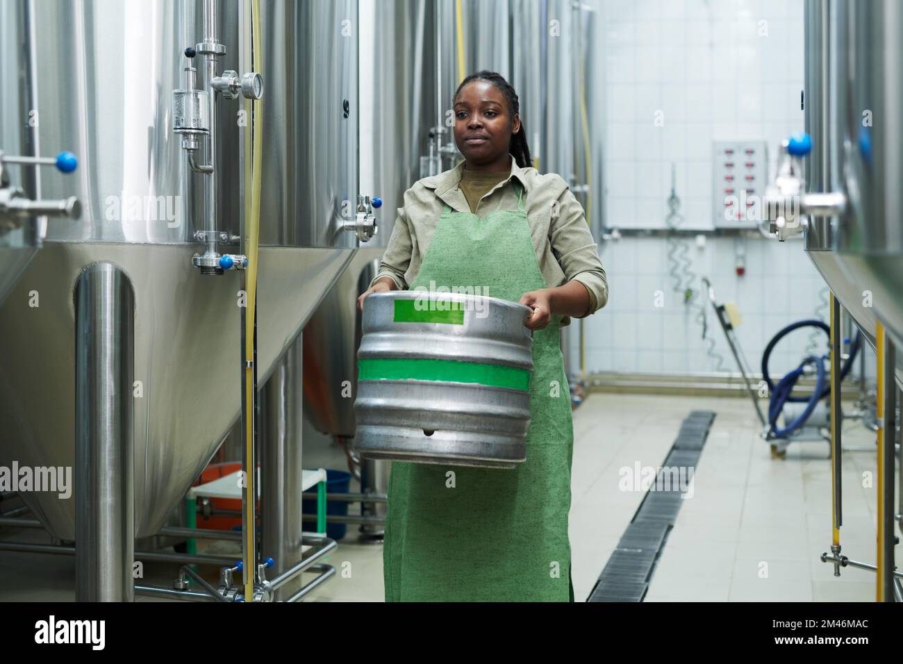 Brewery worker in uniform carring heavy beer keg Stock Photo Alamy
