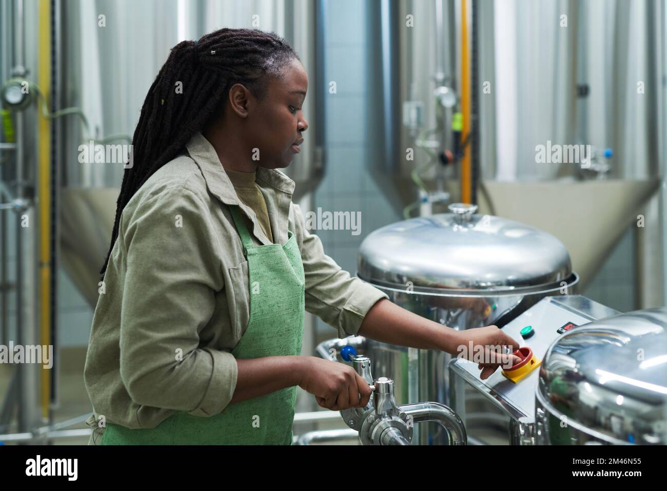 Brewery worker setting equipment for beer production Stock Photo