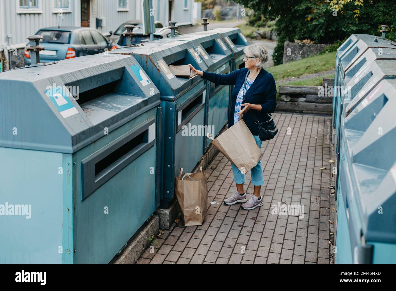 Woman putting cardboard in recycling bin Stock Photo Alamy