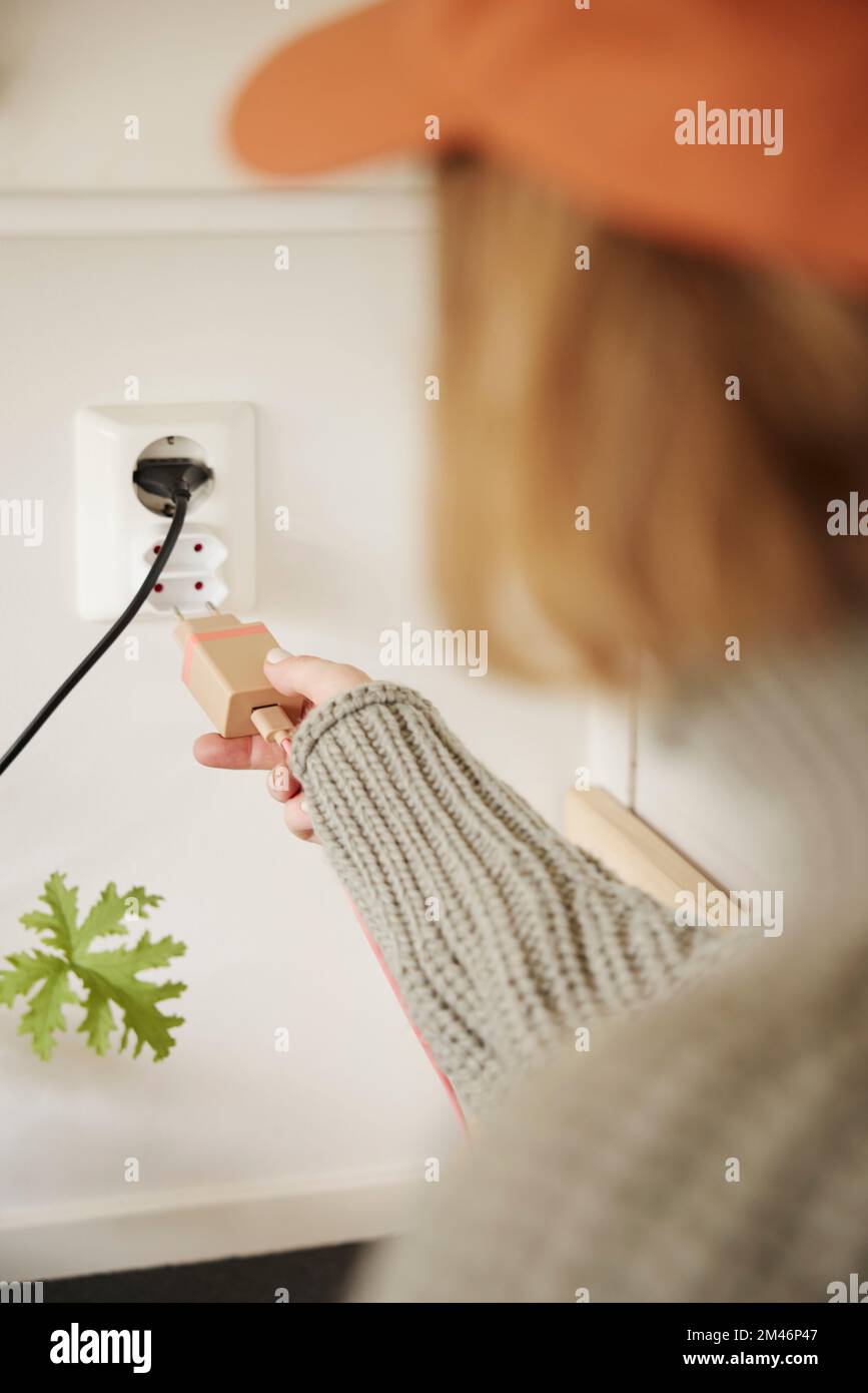 Woman plugging in charger Stock Photo