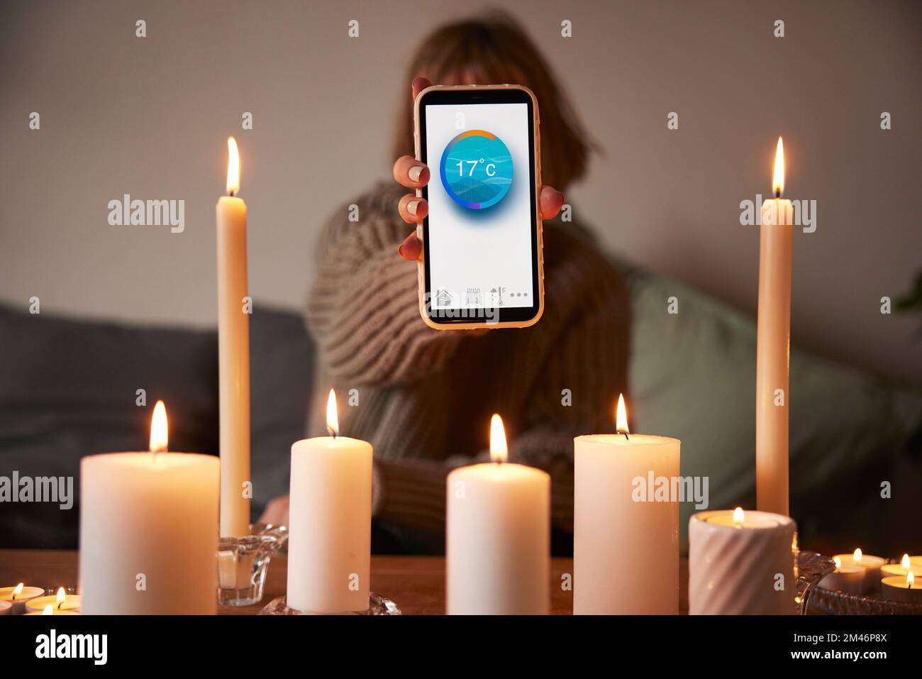 Woman lighting candles and using temperature app Stock Photo Alamy