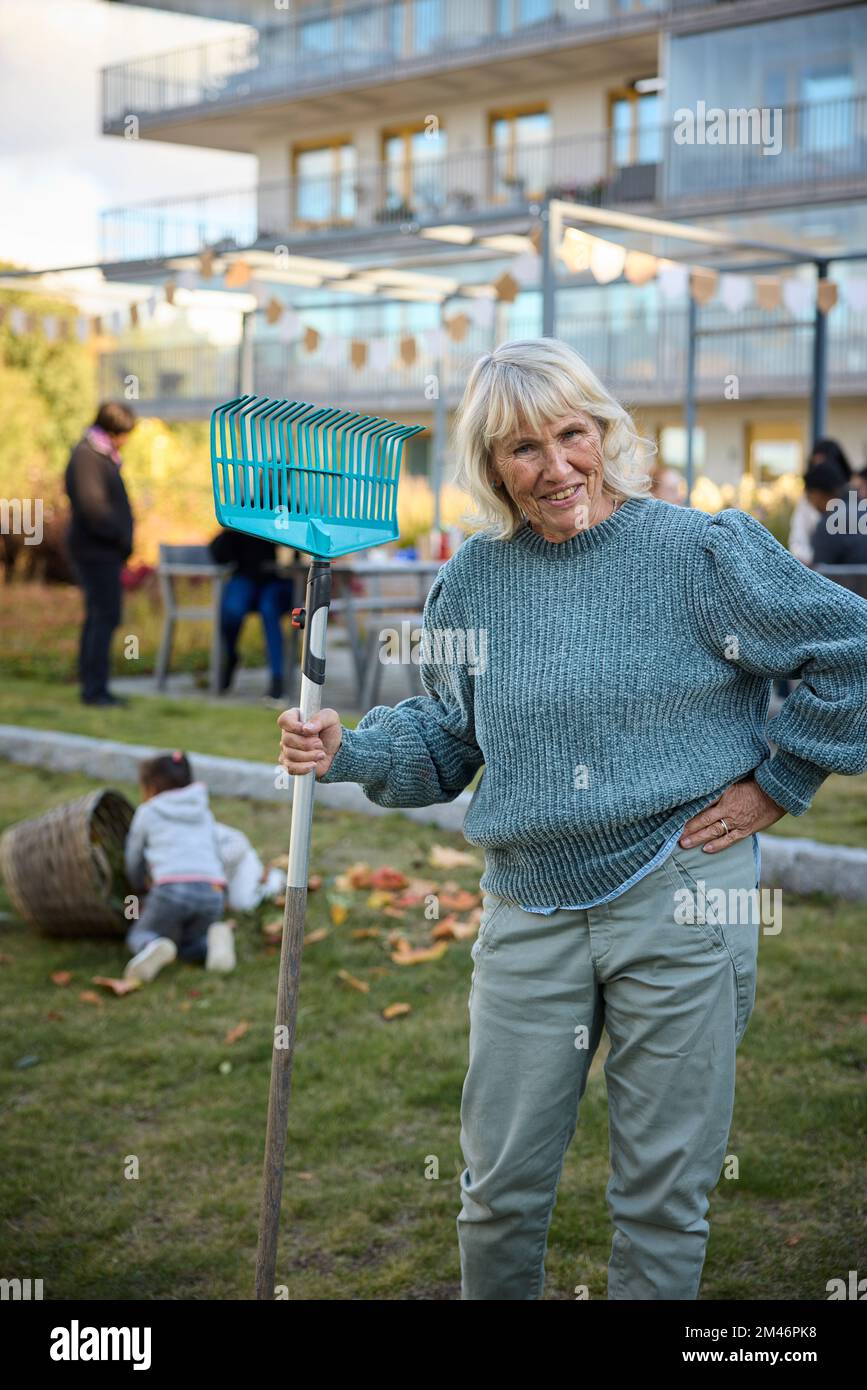 Senior woman standing rake hi-res stock photography and images - Alamy