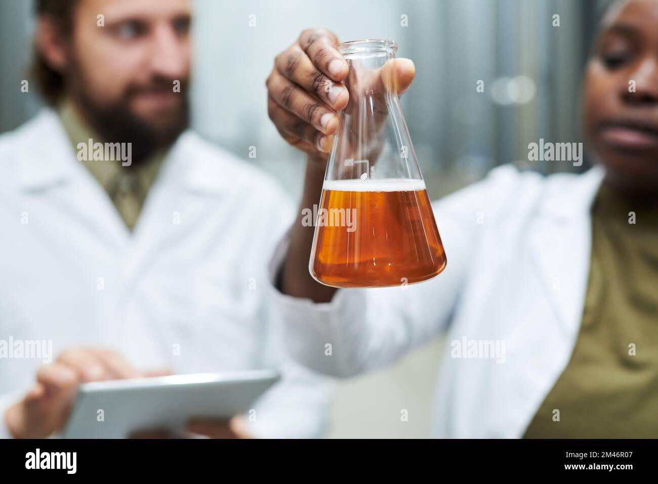 Flask with beer produced at private brewery being checked by inspectors Stock Photo