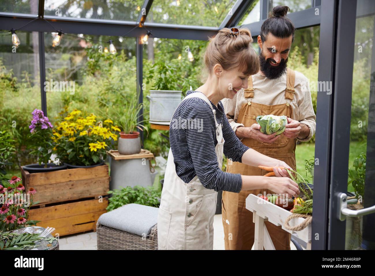 Smiling couple in greenhouse Stock Photo - Alamy