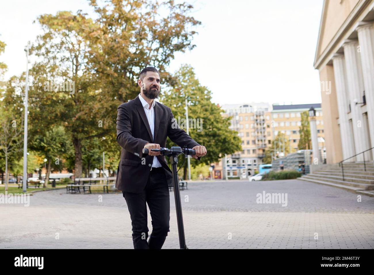 Businessman riding electric push scooter Stock Photo