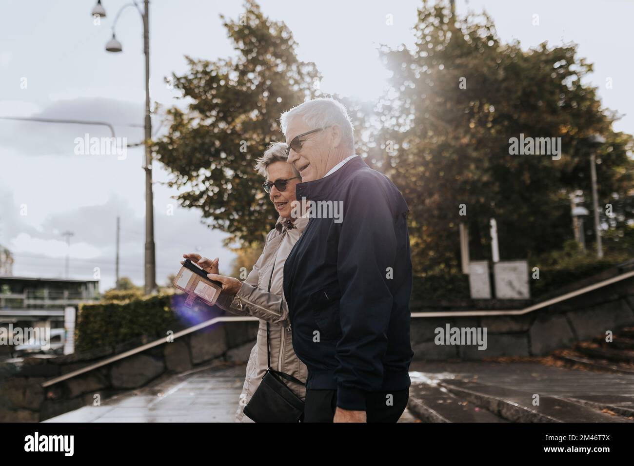 Senior couple using smart phone in city Stock Photo