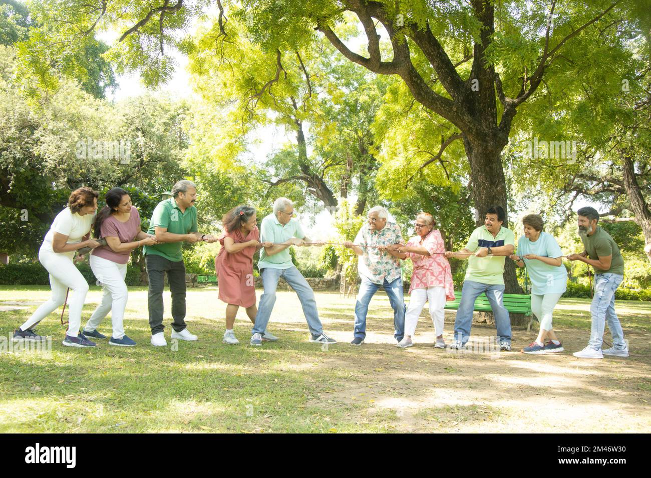 Group Of Senior Indian People Playing Tug War Outdoor In Park. Retirement life. Stock Photo