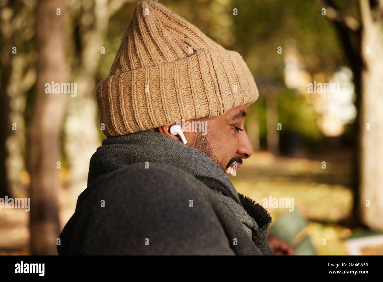 Smiling man sitting on bench Stock Photo