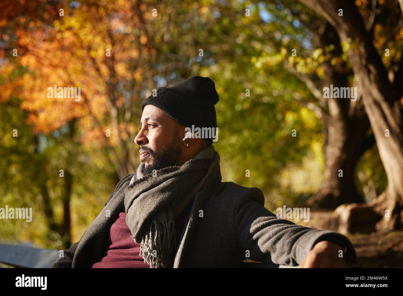 Smiling man sitting on bench Stock Photo
