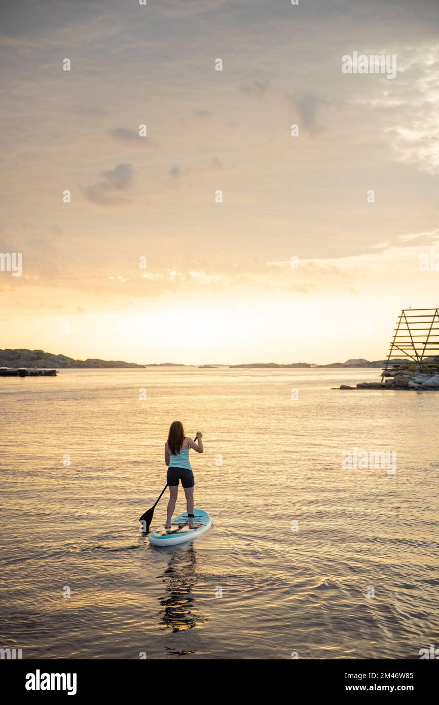 Woman paddleboarding at sea Stock Photo
