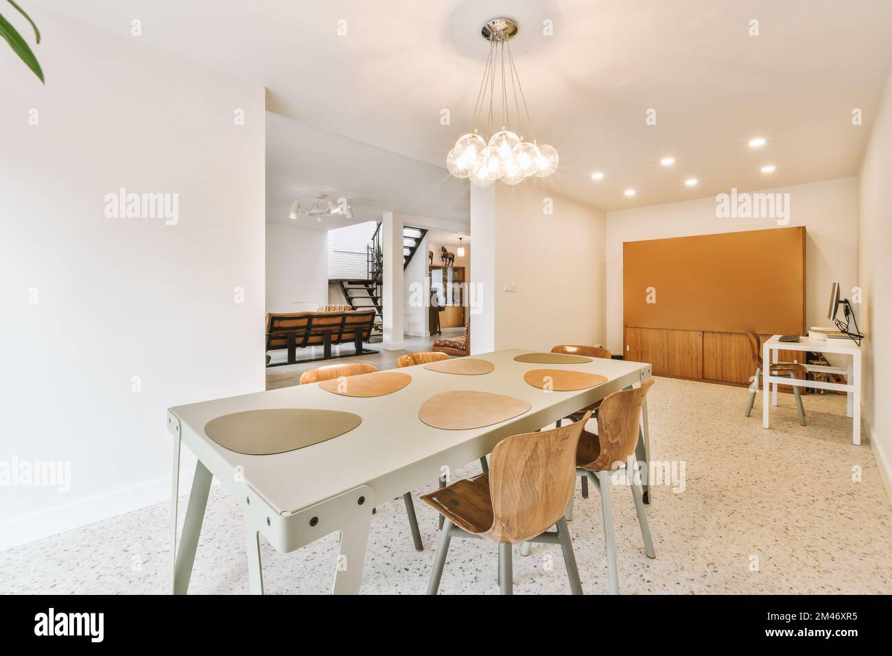 a dining room with white walls and an orange accent wall in the center