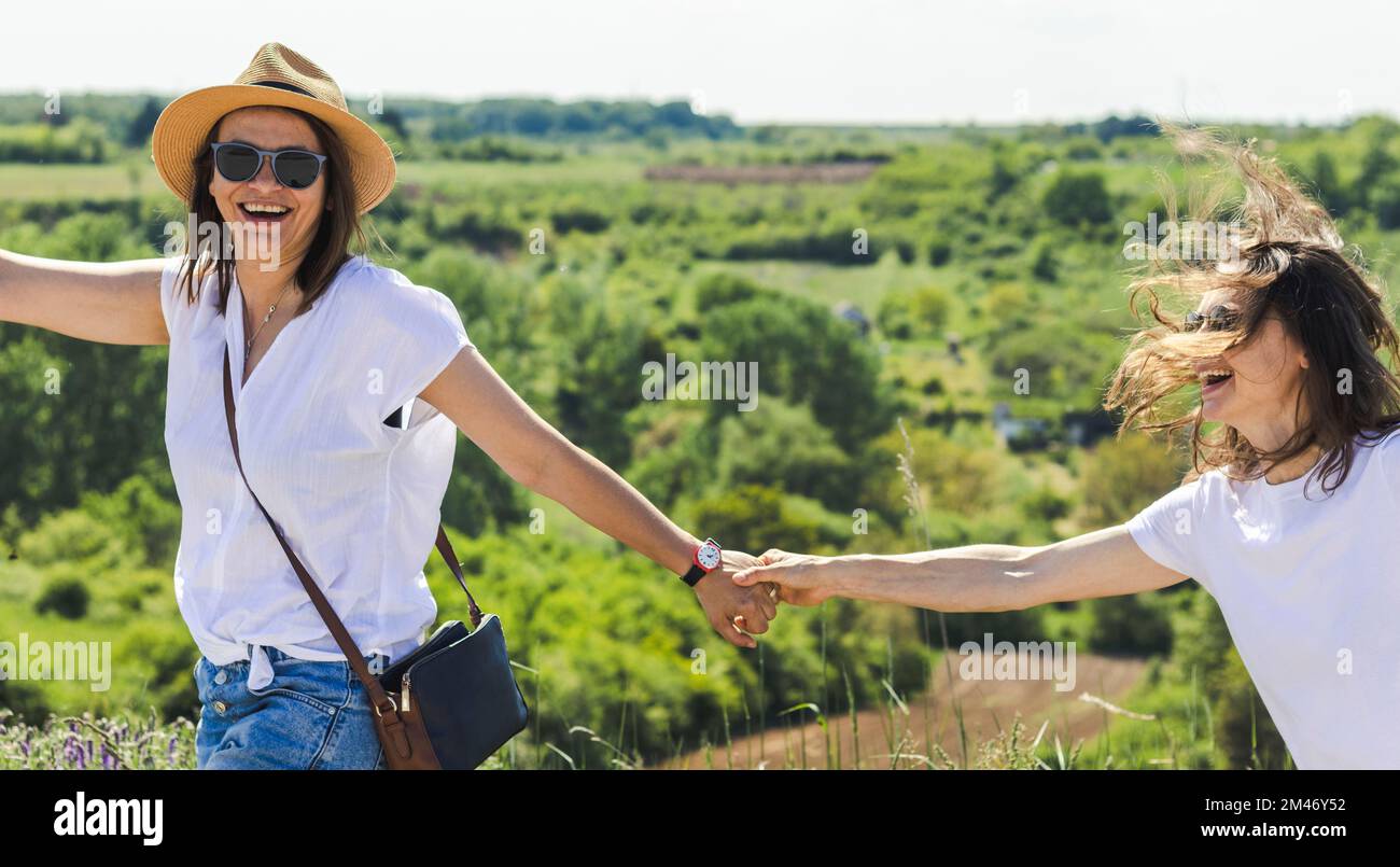 Two happy lesbians having fun in nature, gay couple traveling in nature. Stock Photo
