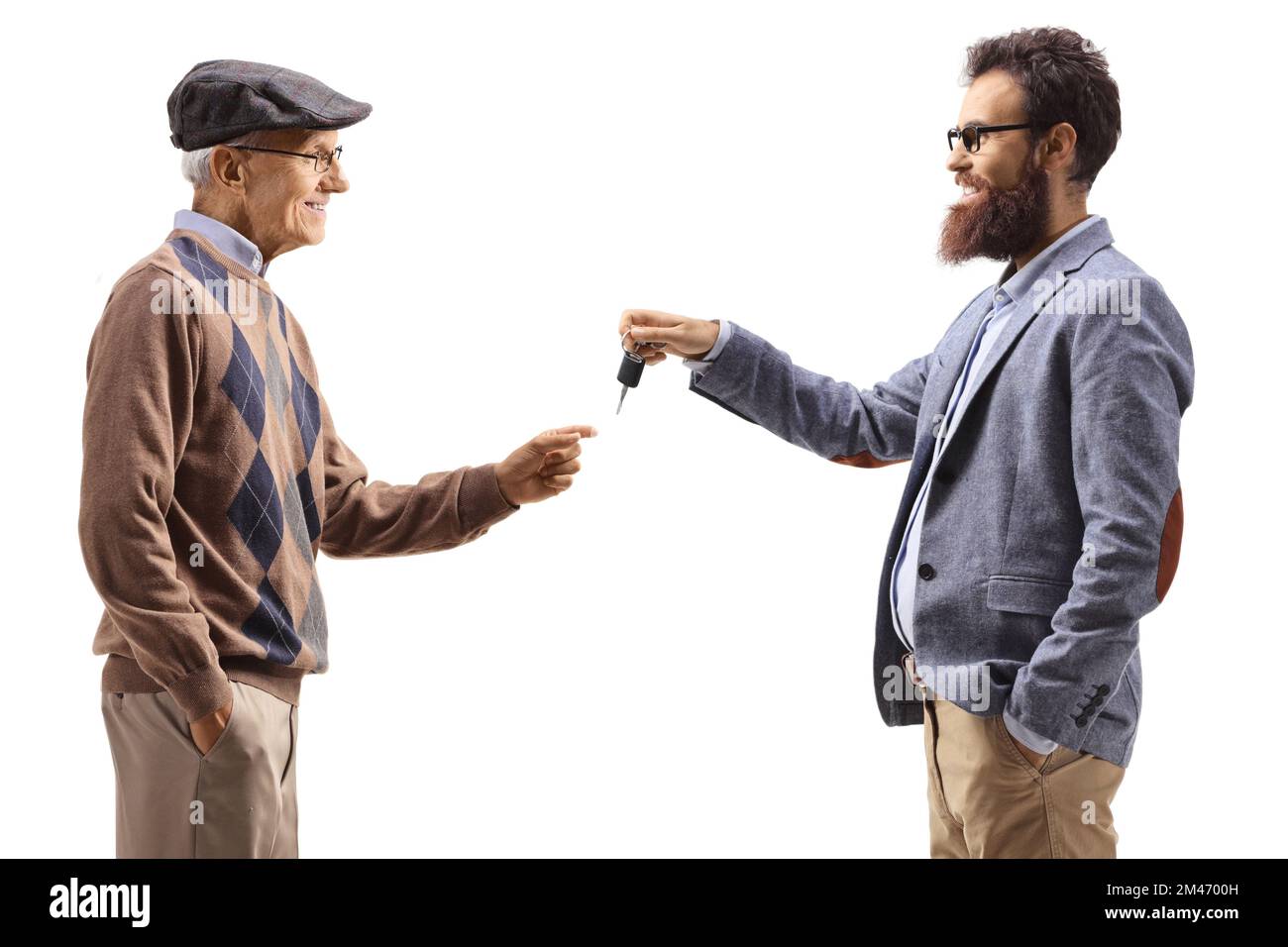 Younger man giving car keys to an elderly man isolated on white background Stock Photo