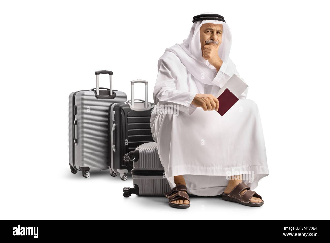 Arab man sitting on a suitcase holding a passport and waiting for a flight isolated on white background Stock Photo