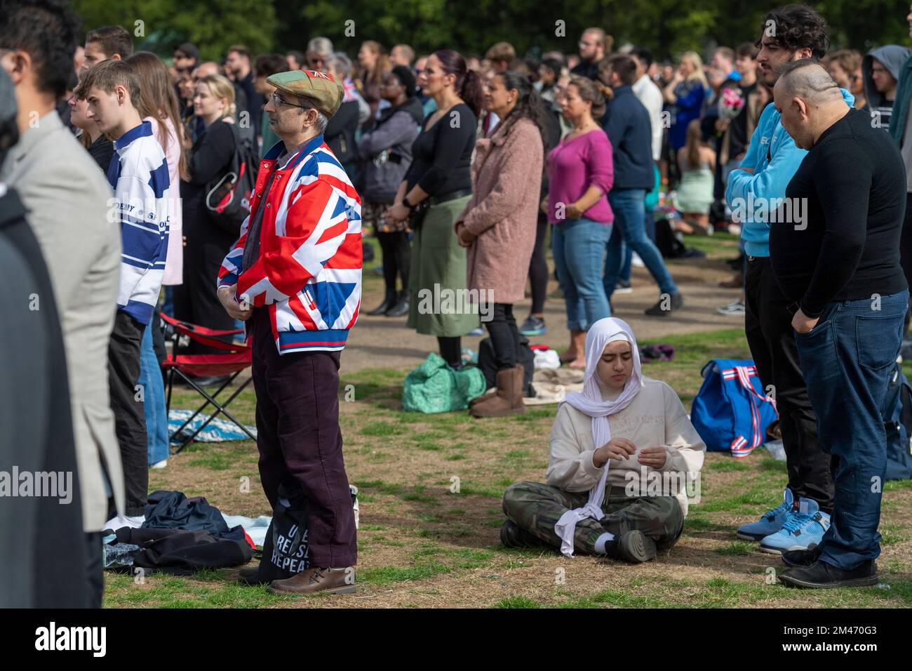 A male mourner wearing a Union Jack jacket, in Hyde park watching the live broadcast of the funeral Her Majesty Queen Elizabeth II taking place in Wes Stock Photo