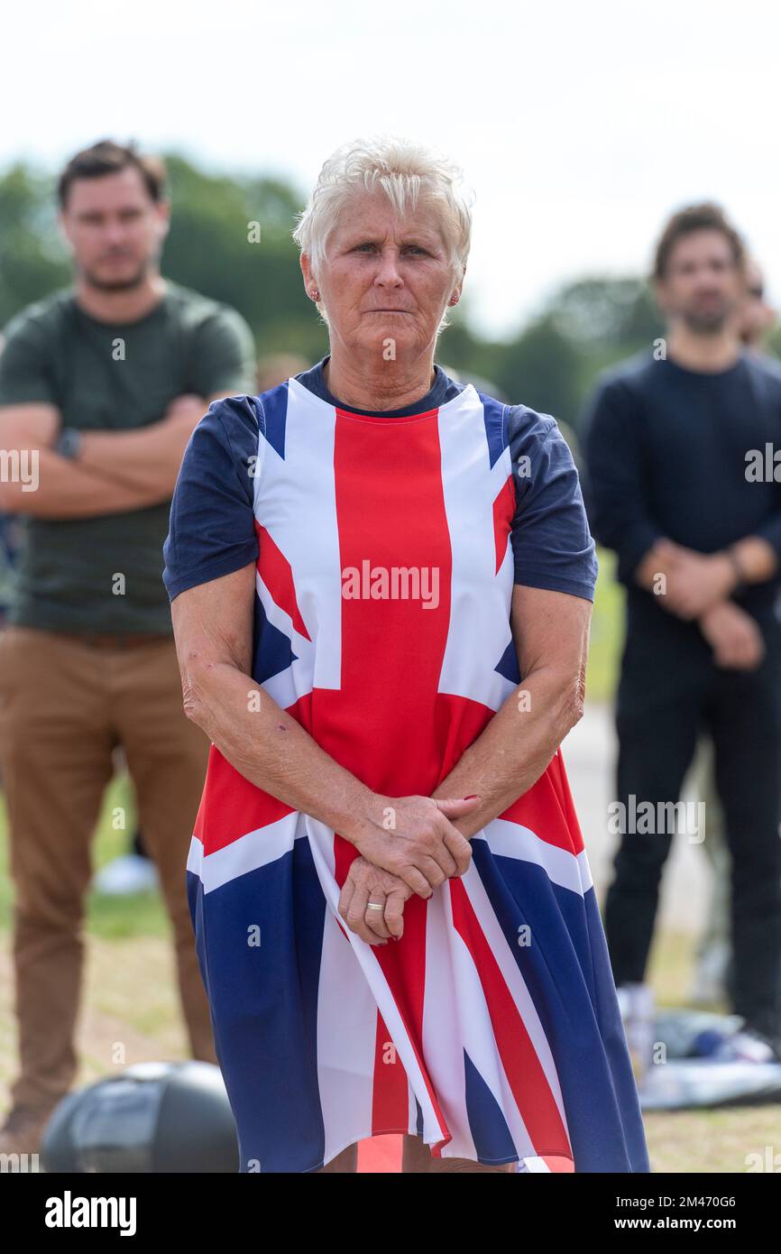A woman mourner wearing a Union Jack dress, in Hyde park watching the live broadcast of the funeral Her Majesty Queen Elizabeth II taking place in Wes Stock Photo