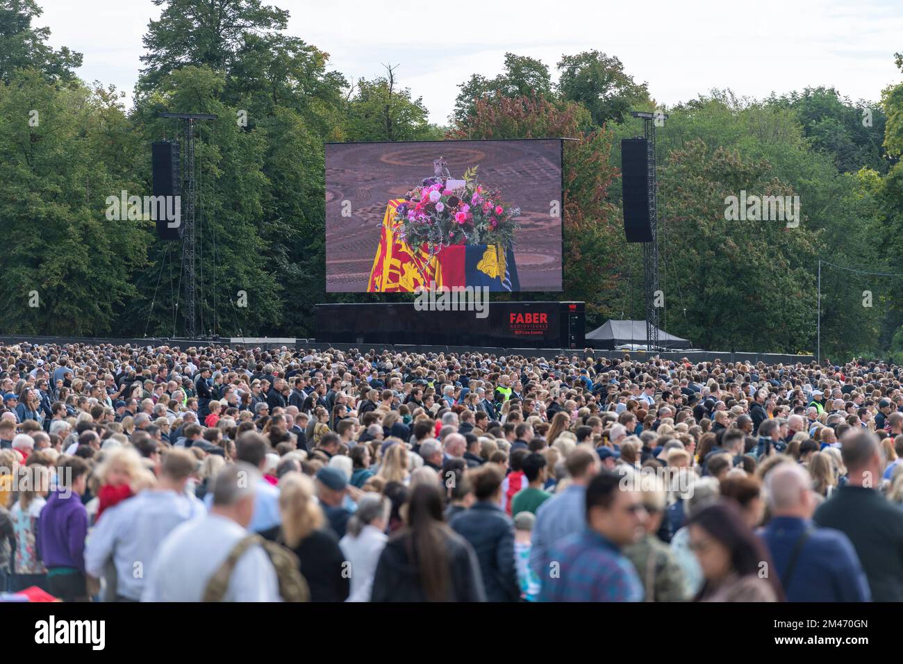 A large crowd mourners in Hyde park watching the live broadcast of the funeral Her Majesty Queen Elizabeth II taking place in Westminster Abbey, on gi Stock Photo