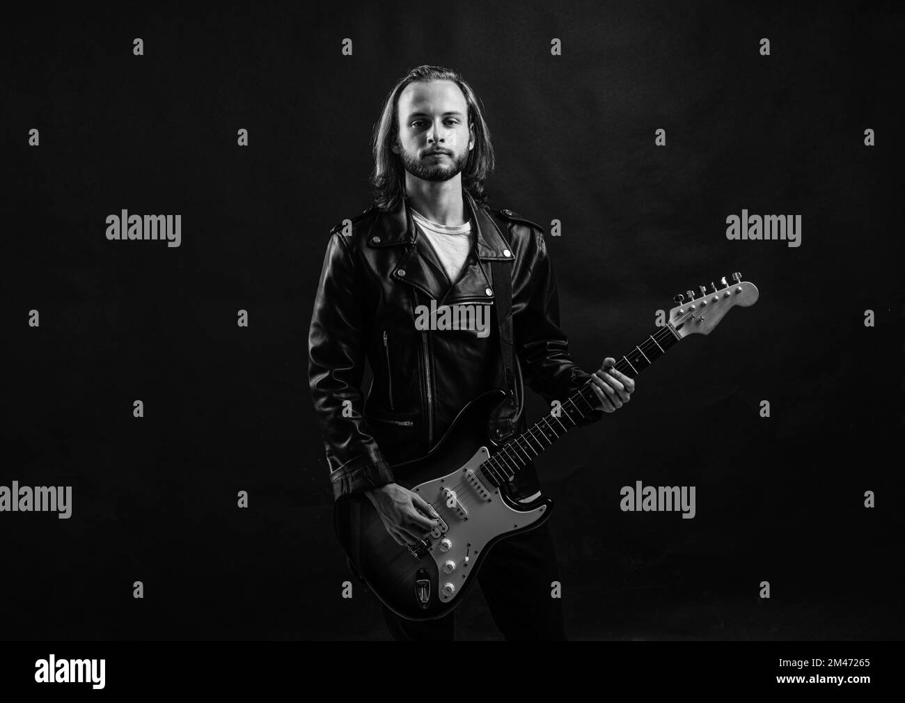 bearded rock musician playing electric guitar in leather jacket, guitarist Stock Photo