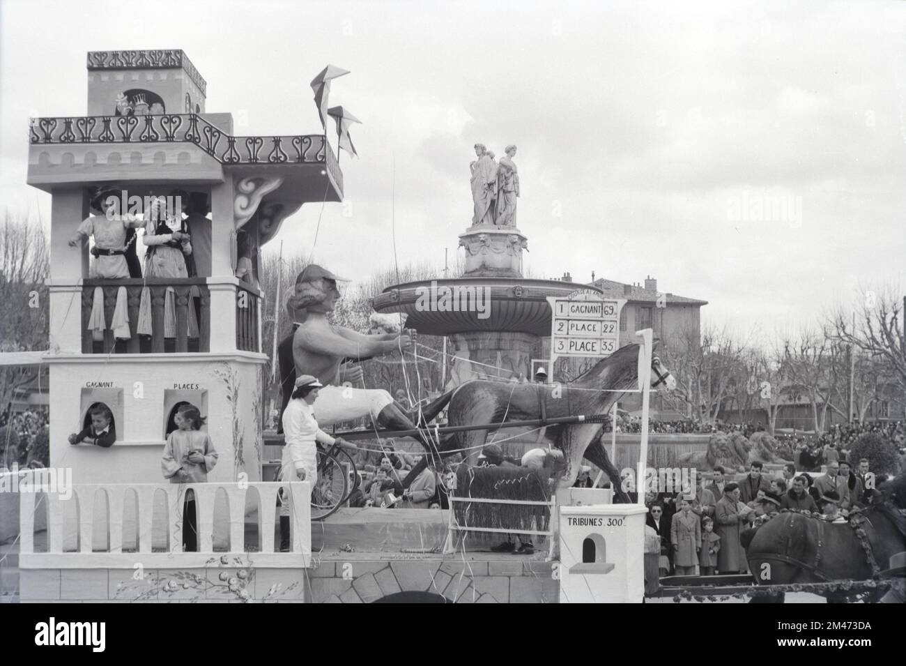 Spring Carnival Float on Horse Riding or Horse Racing Theme Passing the Rotonde Fountain at the Western End of the Cours Mirabeau Aix or Aix-en-Provence Provence France. Vintage Black and White or Monochrome Image 1954 Stock Photo