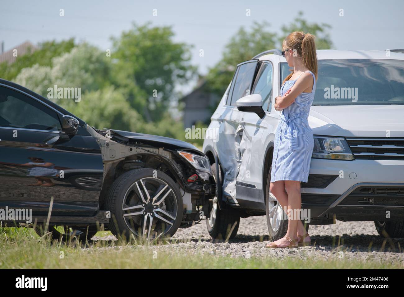 Sad female driver standing on street side shocked after car accident ...