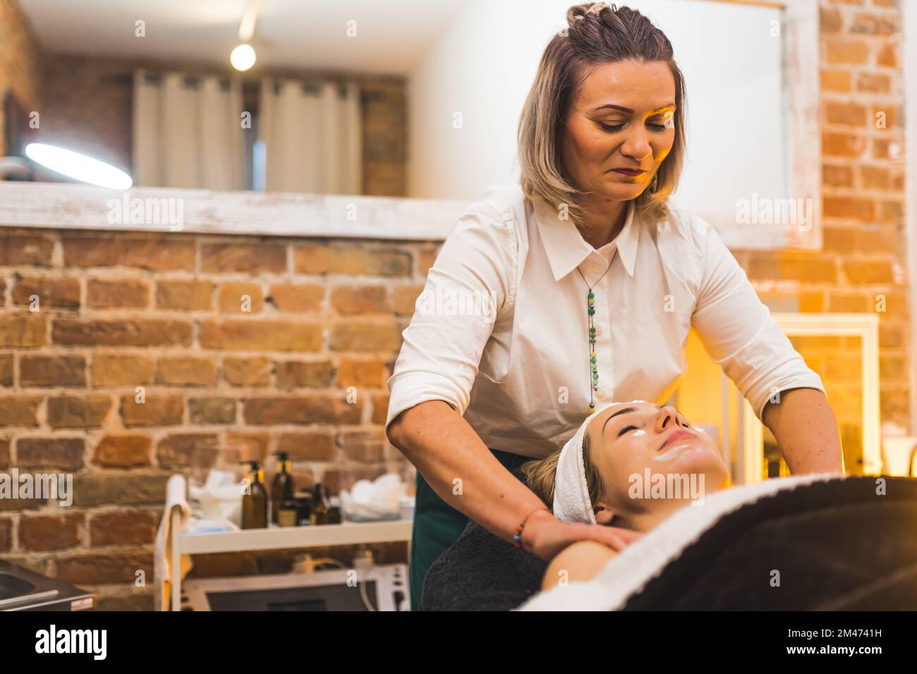 Focused massage therapist expert during neck and arms massage in her