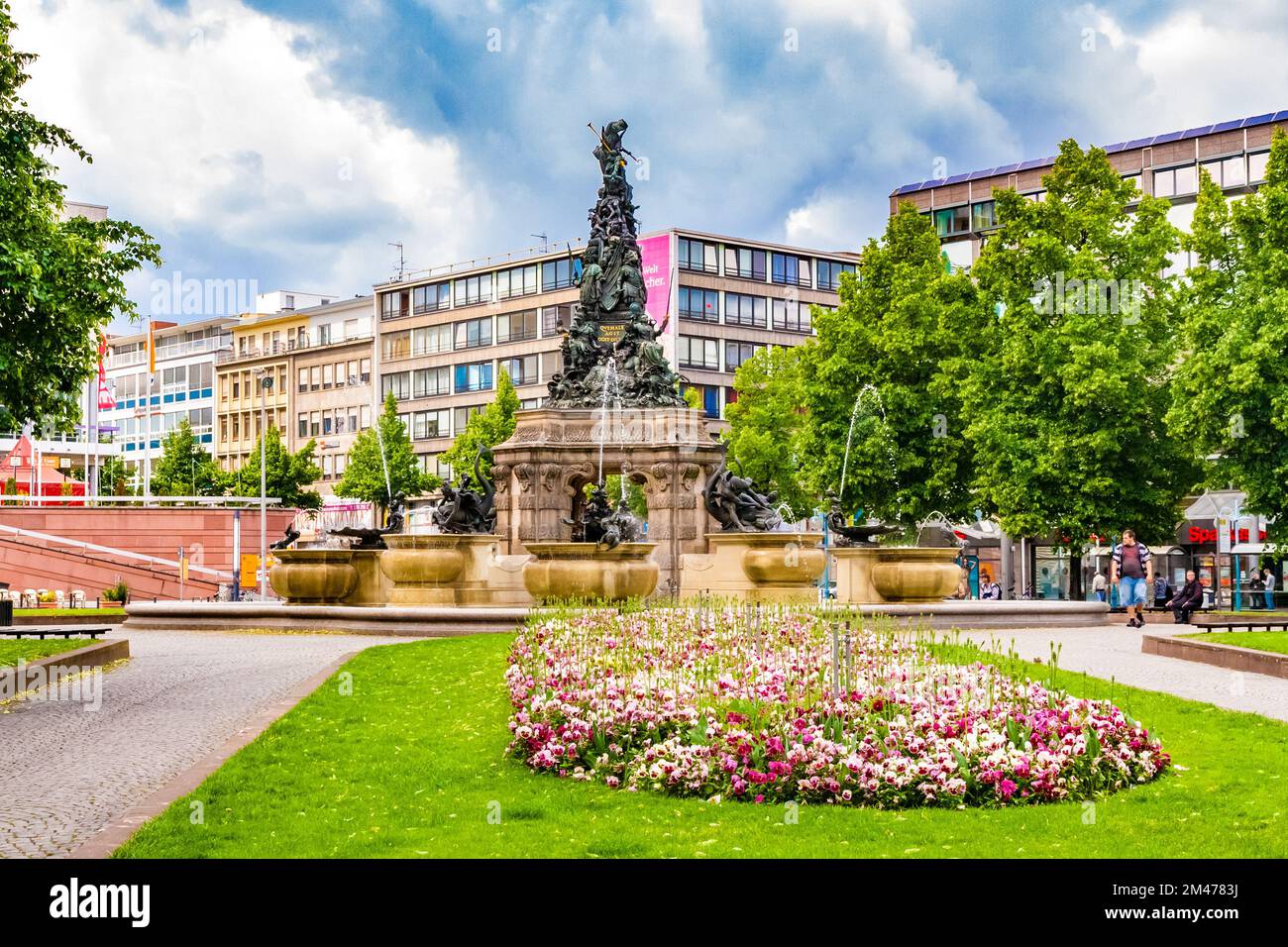 Picturesque view of a flowerbed full of white and pink garden pansies on the square Paradeplatz with the famous sculpture Grupello Pyramid in the back Stock Photo