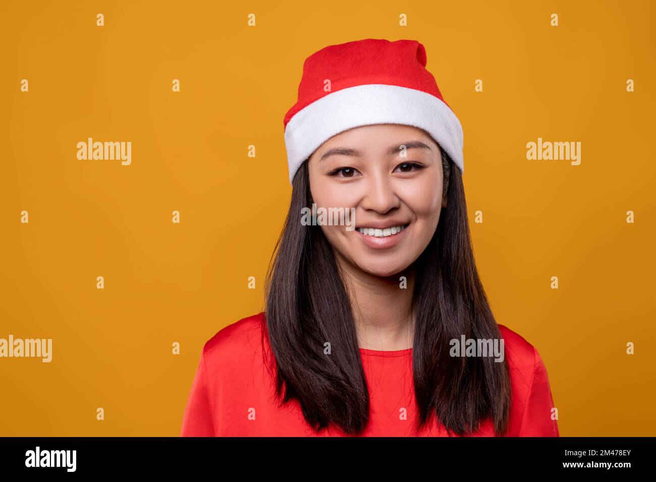 Cute asian smiling young woman in santa hat Stock Photo