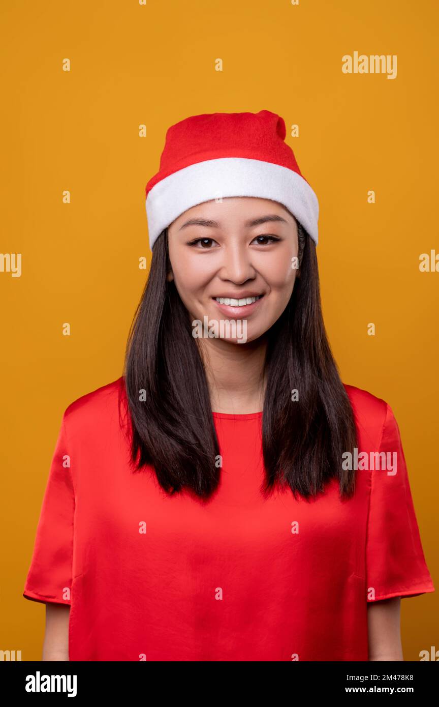 Cute asian smiling young woman in santa hat Stock Photo