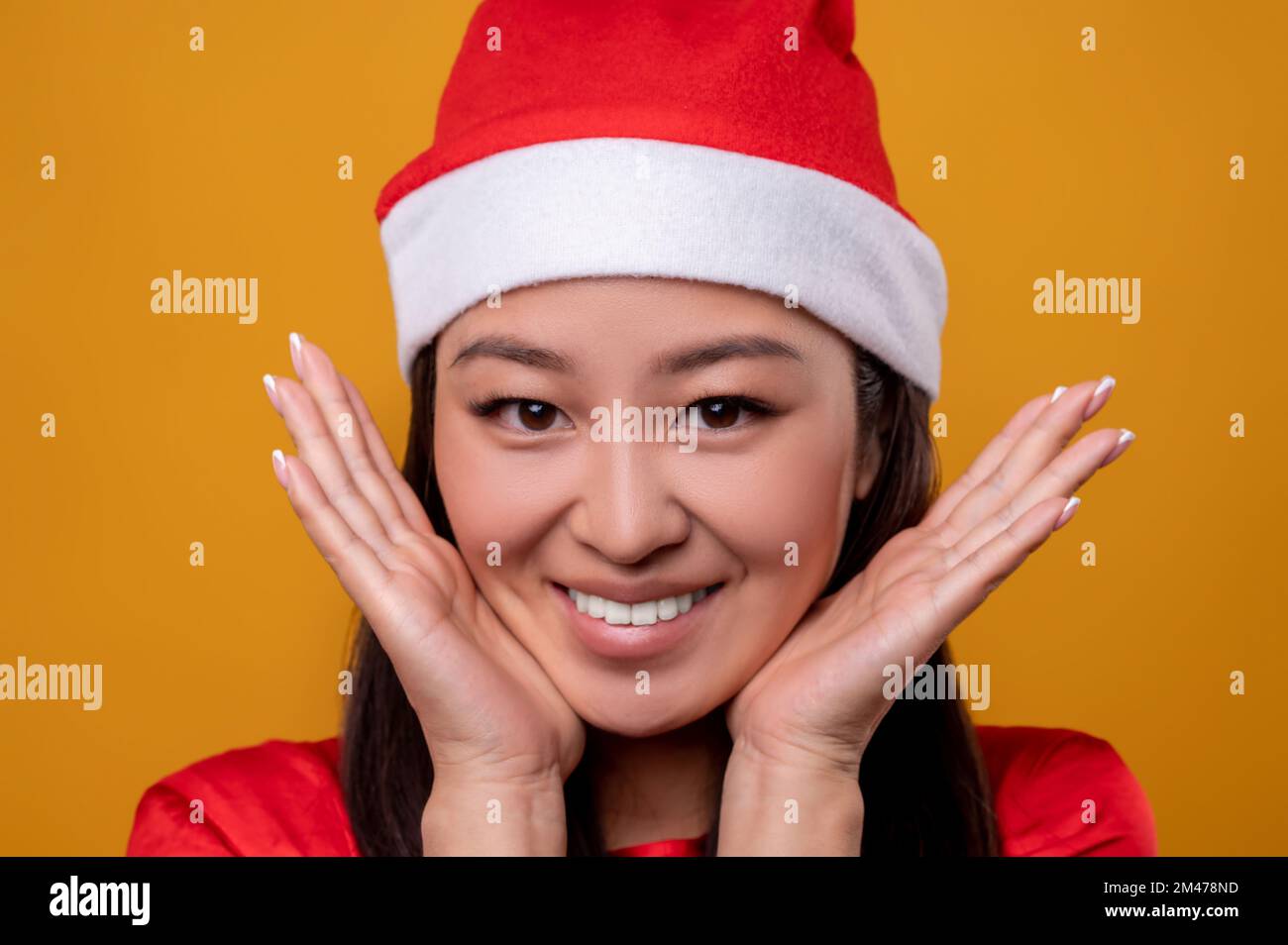 Cute young woman in red santa hat feeling happy and enjoyed Stock Photo