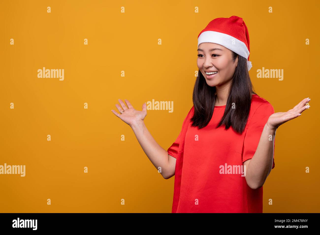 Cute young woman in red santa hat feeling happy and enjoyed Stock Photo