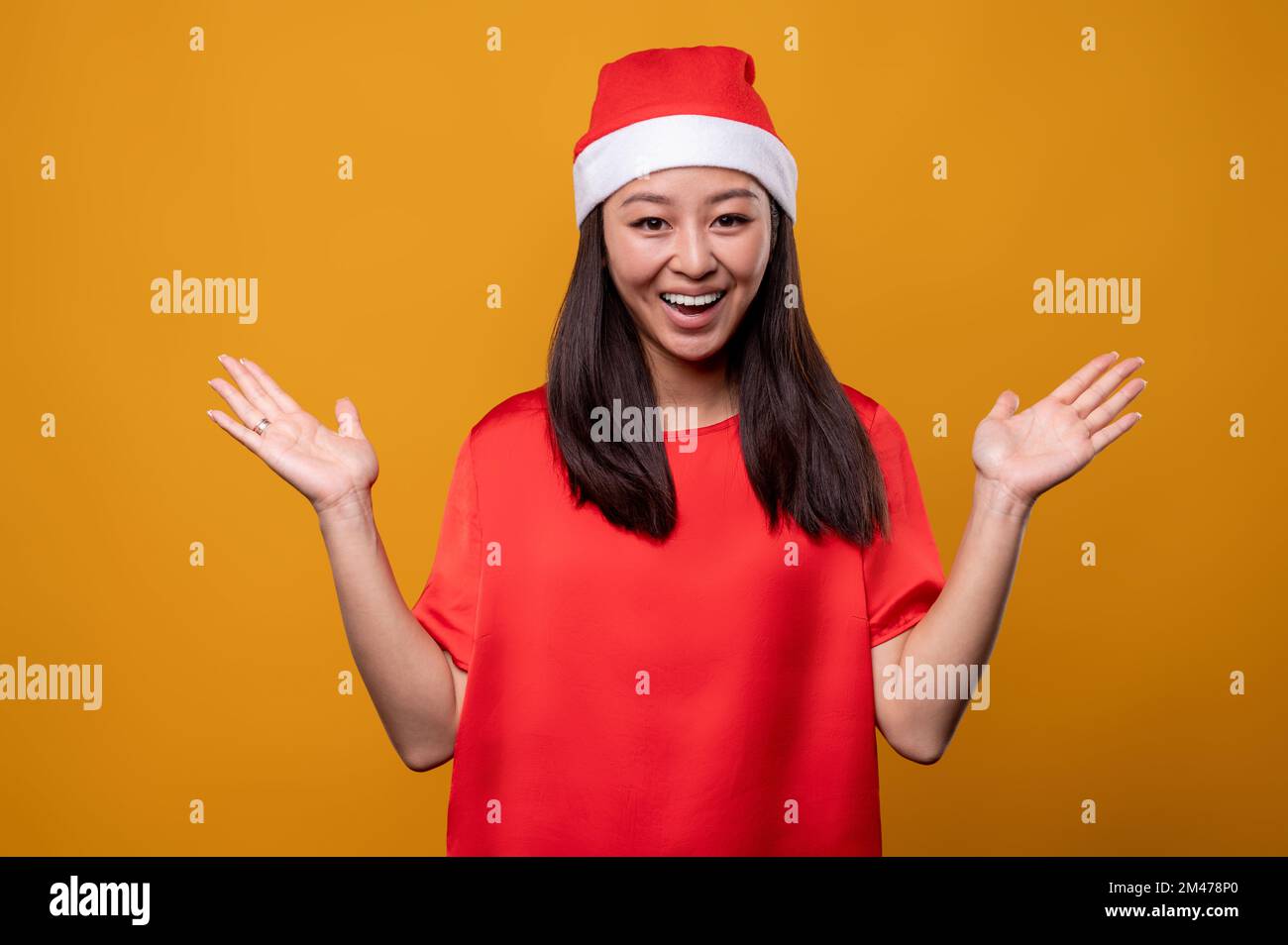 Cute young woman in red santa hat feeling happy and enjoyed Stock Photo