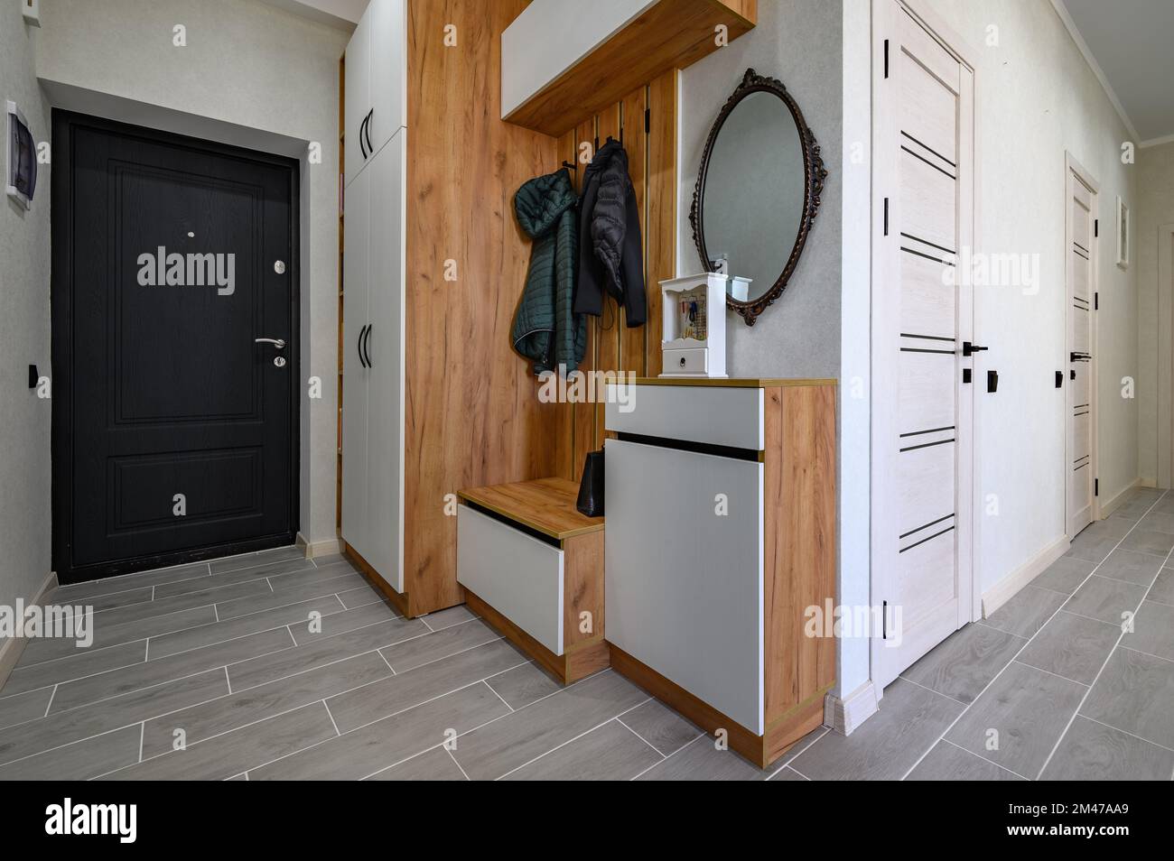 Small entrance hallway interior with shoe storage, hanger stand and mirror Stock Photo