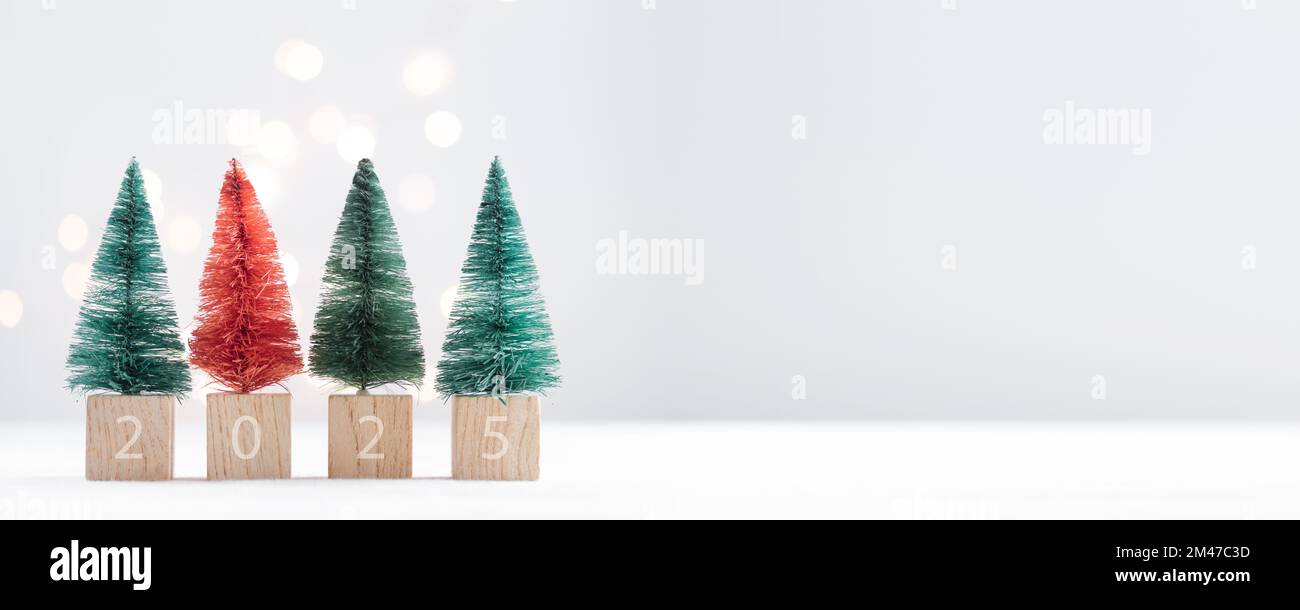 Four cute Christmas miniature fir trees 2025 on a white table with