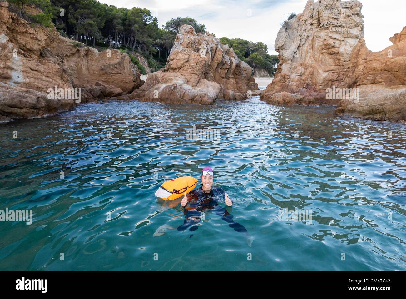Female swimmer swimming in the sea near the rocks Stock Photo - Alamy