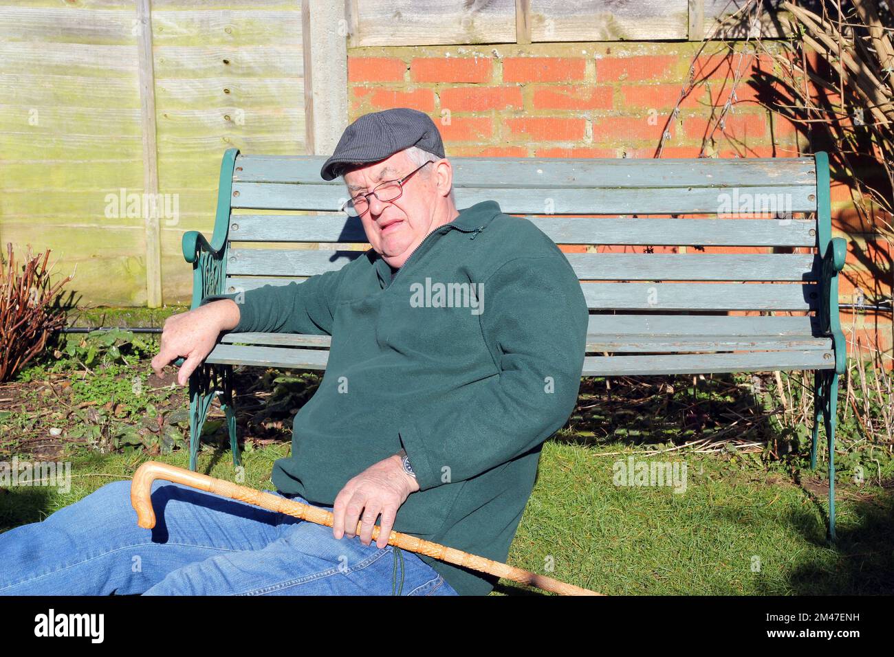 Old or elderly man fallen over. Sitting on the ground. Stock Photo