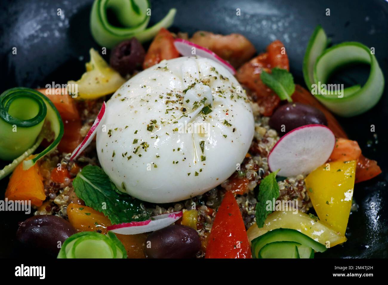 mediterranean style tomato mozzarella quinoa salad in a black plate