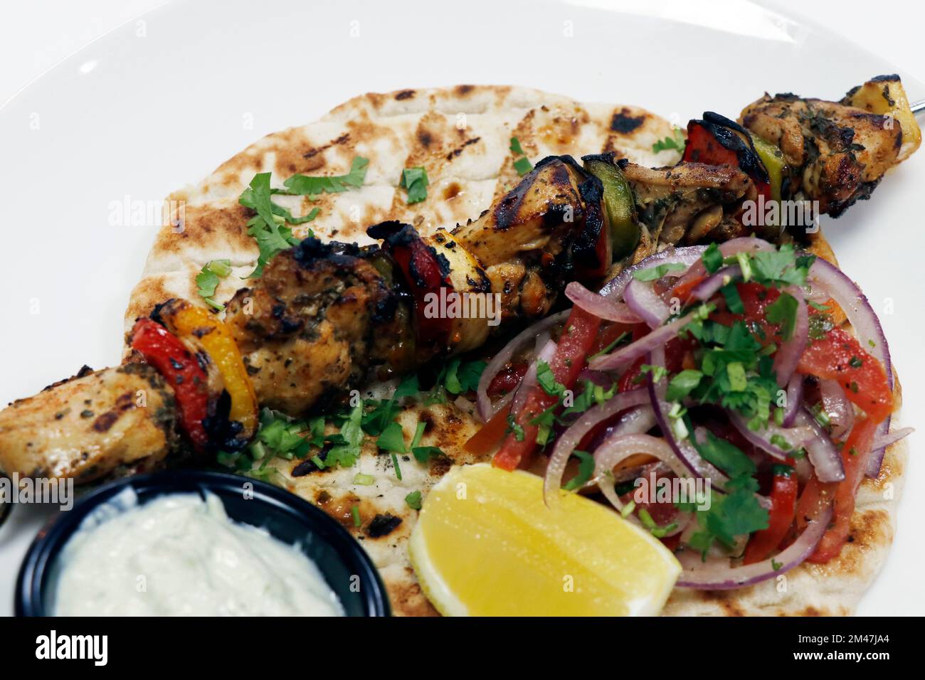 greek mediterranean style chicken souvlaki kebab with salad, pita bread and tazki dip Stock