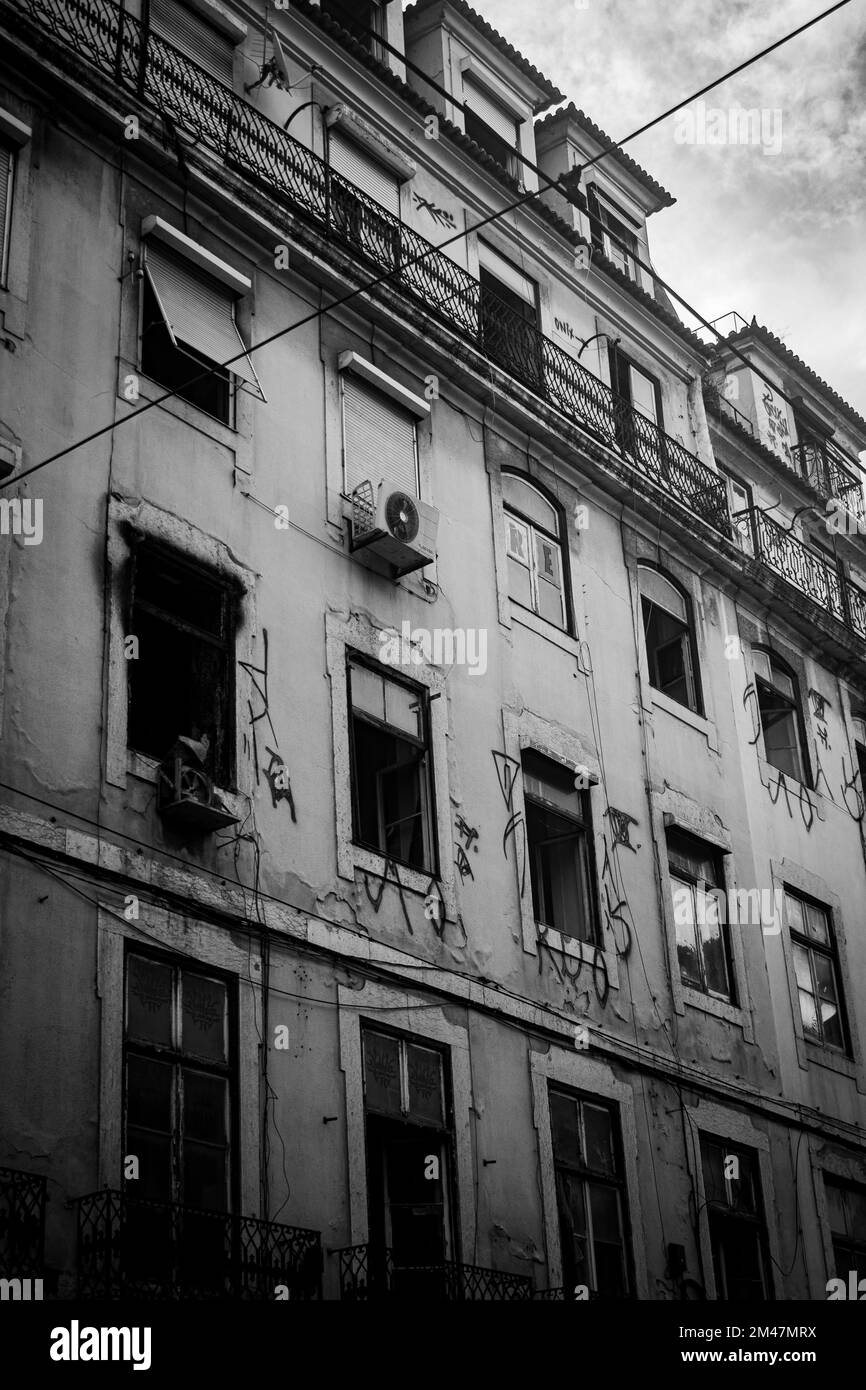 A vertical grayscale shot of an old abandoned building's facade in Rua Augusta, Lisbon, Portugal Stock Photo