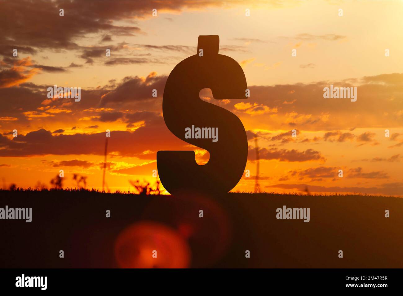 Dollar money sign at sunset in the rays of the setting sun. Sunset currency. Devaluation of money.. Stock Photo
