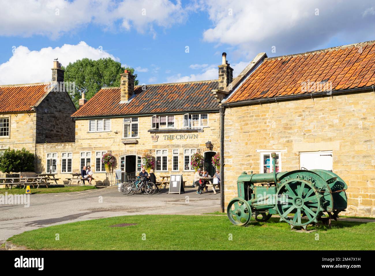 Hutton le Hole North Yorkshire Ryedale Folk Museum with old tractor and the Crown pub in Hutton le Hole North yorkshire England UK GB Europe Stock Photo