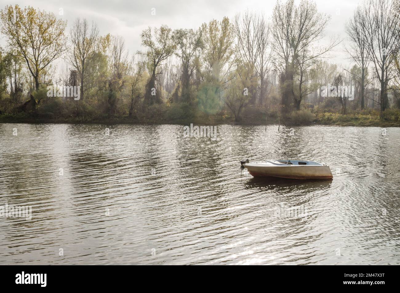 Wooden boat moored along the shore of the lake in water Stock Photo - Alamy