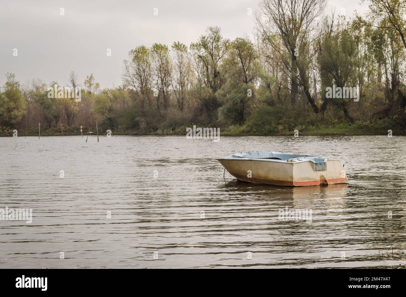 Wooden boat moored along the shore of the lake in water Stock Photo - Alamy