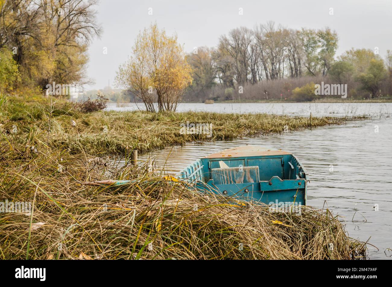 Wooden boat moored along the shore of the lake in water Stock Photo - Alamy